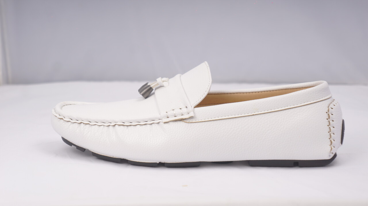 White loafer photographed on a pale background